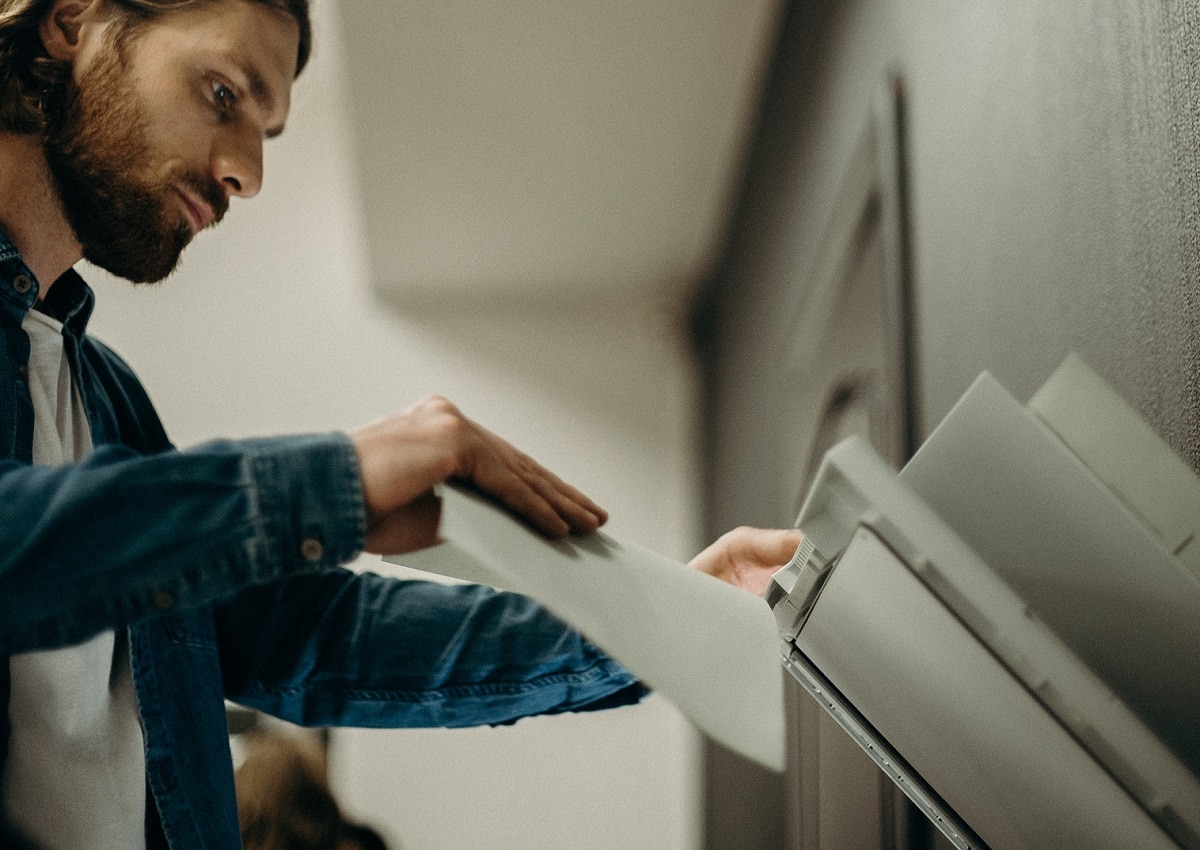 Een man legt een document op een kopieer- en scanmachine