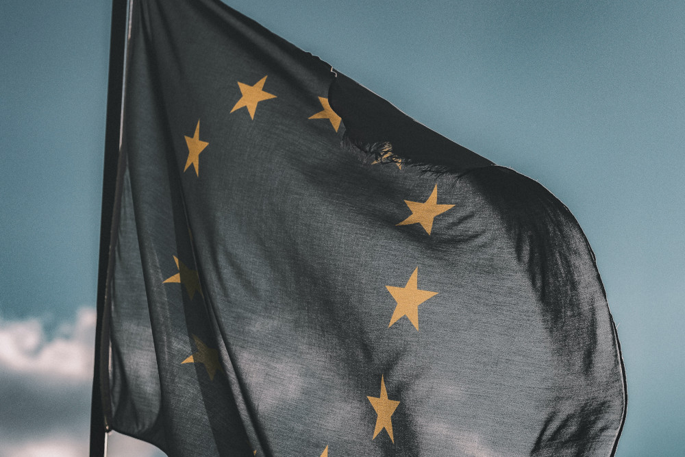 Foto van de vlag van de Europese Unie. Een blauwe vlag met gouden sterren in een cirkel.