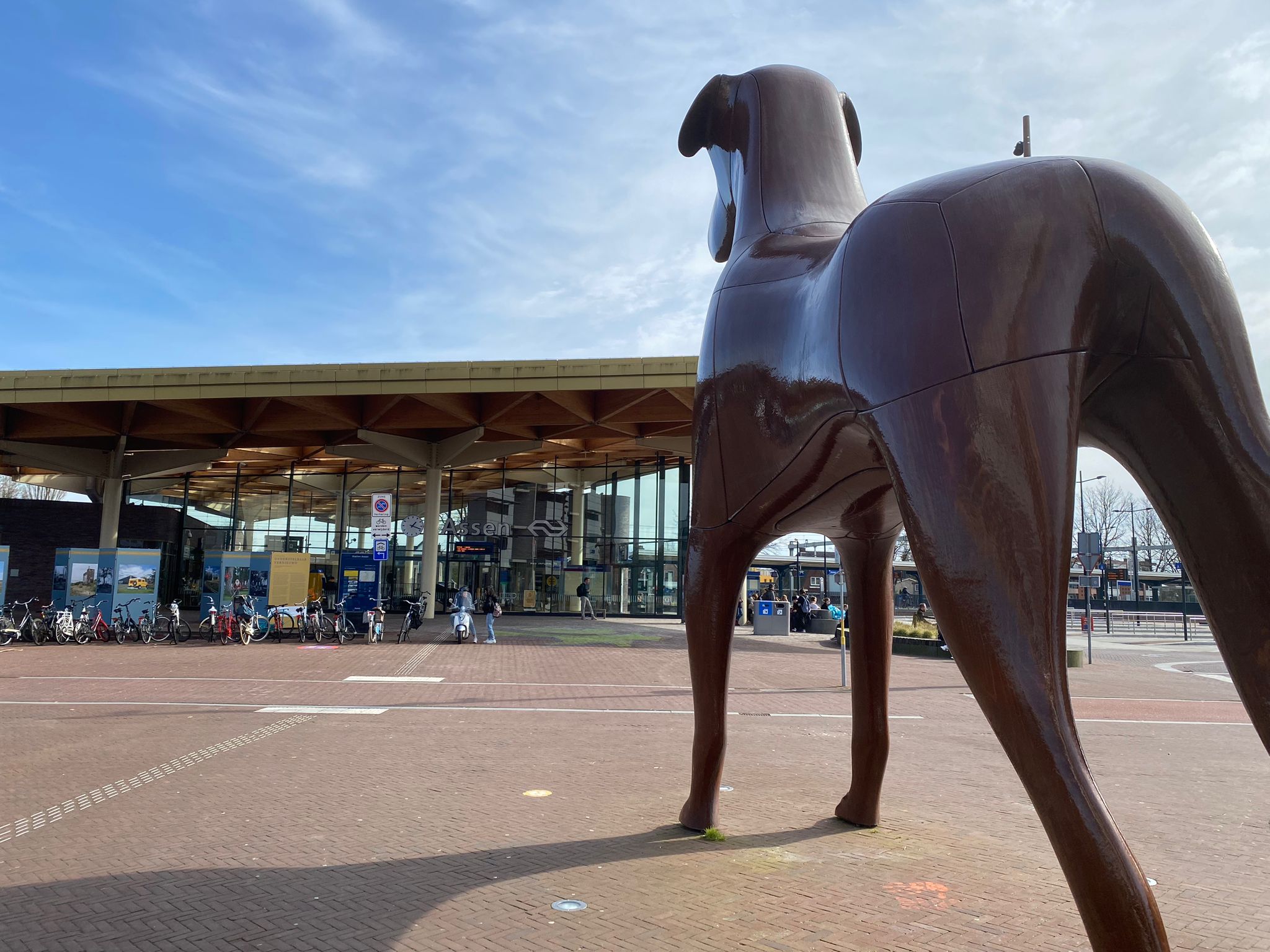 Een beeld van een grote hond voor het station in Assen