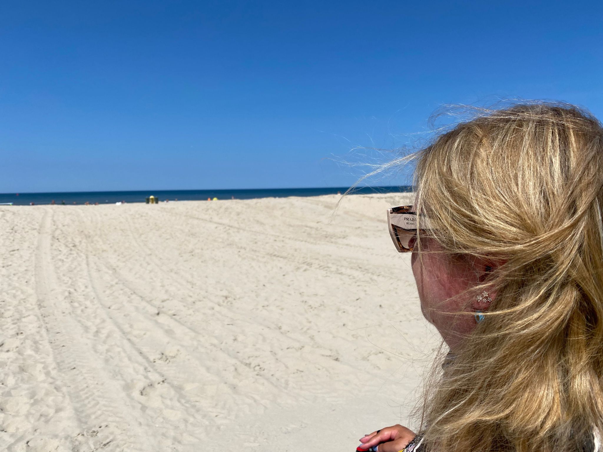 Judith vanachter gezien op een strand terwijl ze kijkt naar de zee