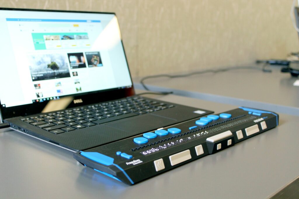 Laptop met daarop aangesloten een braille toetsenbord