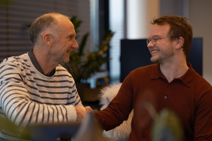 Alex Klijn en Pim Teeuwisse geven elkaar de hand en lachen naar elkaar