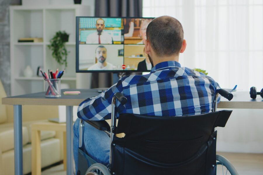 man in een rolstoel heeft een online videogesprek met zijn dokter