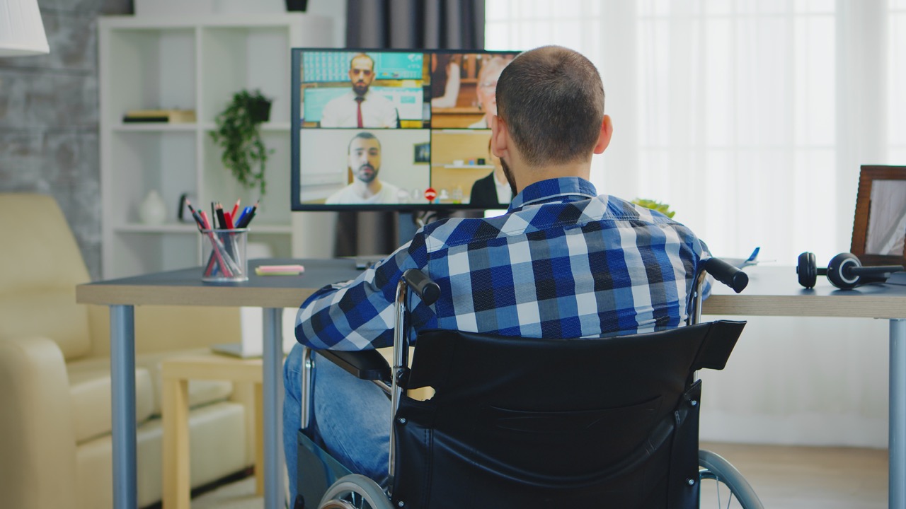 man in een rolstoel heeft een online videogesprek met zijn dokter