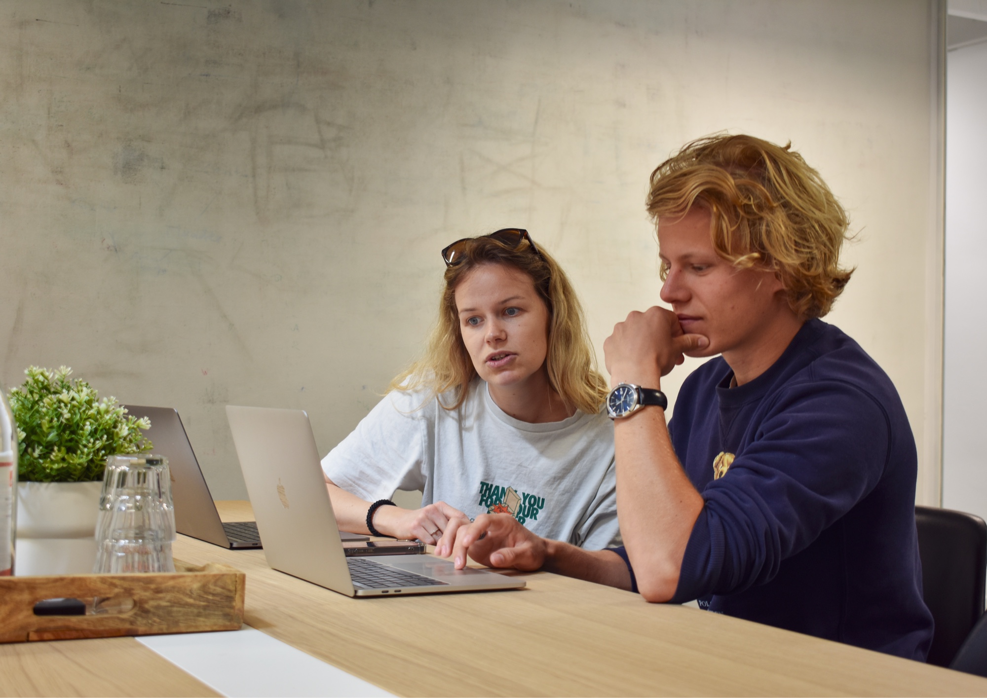 Steffi en Menno zitten in een overlegruimte in het kantoor van Digitaal Toegankelijk. Ze kijken samen naar een laptop.