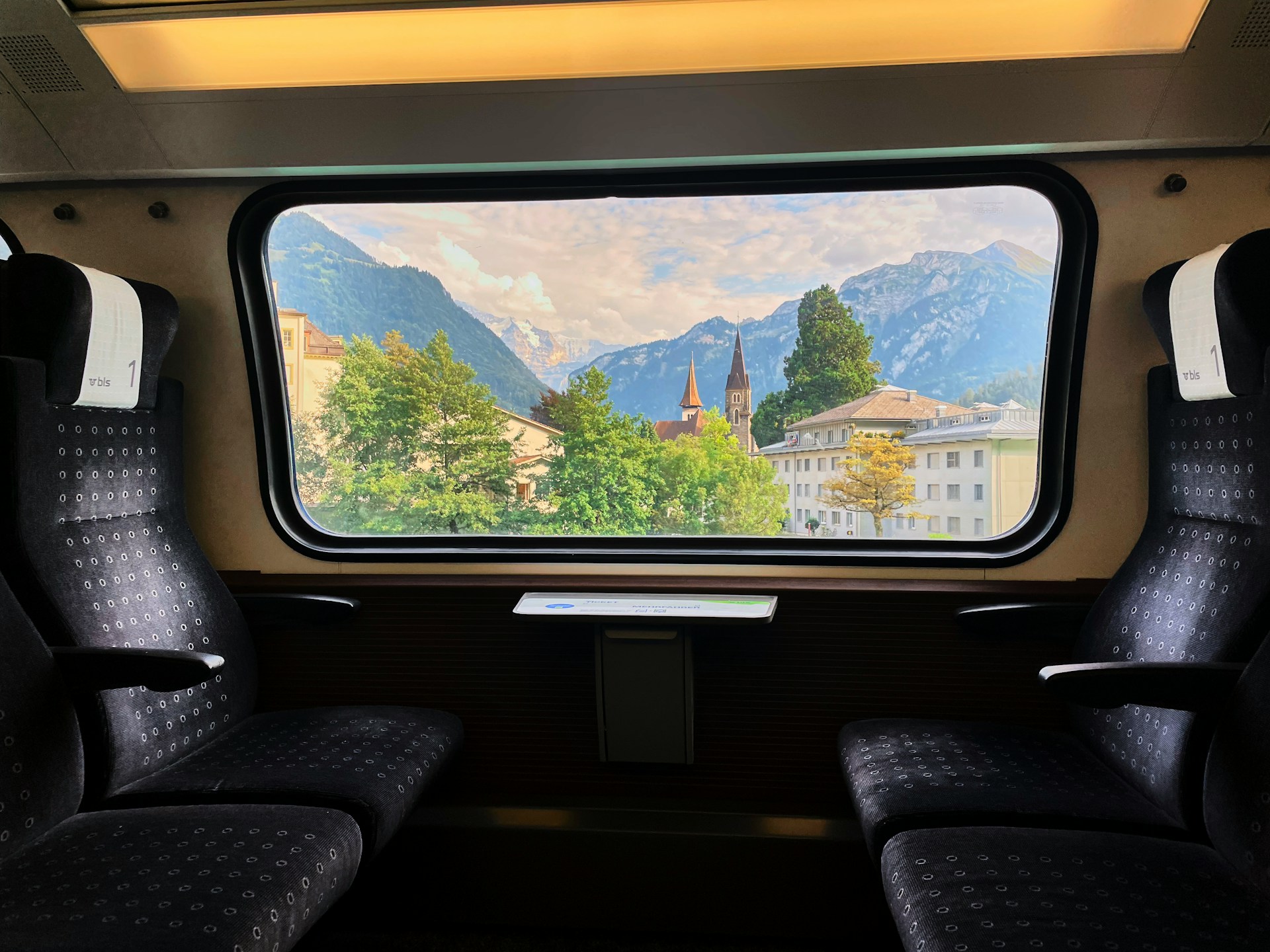 uitzicht vanuit een trein op een bergachtig, groen landschap